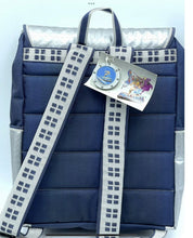 Load image into Gallery viewer, Back view of the blue backpack showing padded straps and attached tag.