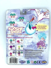 Load image into Gallery viewer, Back view of the Koosh kooshie babies TRUCIOLONES packaging showing game instructions and colorful graphics in blue, pink,…