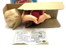 Load image into Gallery viewer, Corner view of Mattel 1982 Baby That Away doll highlighting blonde hair and heart logo.