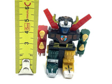 Load image into Gallery viewer, Front view of the 1984 mini Voltron robot with a ruler for size reference.
