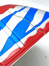 Load image into Gallery viewer, Detail of a decorative lid with wavy design and colorful stripes.
