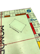 Load image into Gallery viewer, Detail view of the Monopoli game board with game pieces, dice, and money.