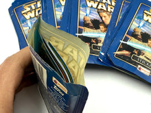 Load image into Gallery viewer, Close-up detail of an opened Star Wars trading card pack showing cards inside.