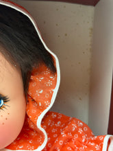 Load image into Gallery viewer, Detail close-up of the doll's face with flower accessory.