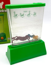 Load image into Gallery viewer, Close-up of the transparent container of the Rompin Cowboy Tomy Water Game.