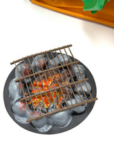 Load image into Gallery viewer, Detail close-up of the metal grill with coals from the camping set
