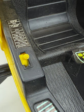 Load image into Gallery viewer, Close-up of the textured black surface with yellow button on the helicopter.