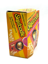 Carica l'immagine nel visualizzatore di Gallery, Side view of Hasbro Skedoodle game box featuring vibrant colors and game title.