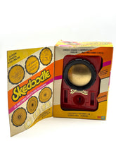 Carica l'immagine nel visualizzatore di Gallery, Packaging detail of vintage toy box with circular graphics and bright colors.