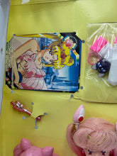 Carica l'immagine nel visualizzatore di Gallery, Detail of the doll's packaging with illustrated background and colorful graphics.