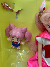Carica l'immagine nel visualizzatore di Gallery, Detail of the doll's packaging showcasing illustrated characters and colorful design.