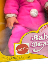 Load image into Gallery viewer, Close-up of the doll in packaging featuring a polka dot design and hooded outfit.