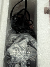 Load image into Gallery viewer, Detail of the black device wrapped in plastic with visible cables