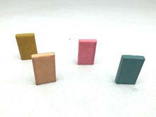 Load image into Gallery viewer, Rear view of Captain Future erasers displaying the plain colored backs in yellow, pink, blue, and orange.