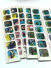 Load image into Gallery viewer, Detail close-up of sticker sheets with various images in blue, green, and yellow.