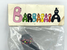 Load image into Gallery viewer, Fabianplastica Barbapapà packaging view showcasing a black toy figure with pink, green, and yellow accents.