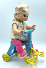 Load image into Gallery viewer, Side view of the Mattel Tippee Toes doll on a tricycle, wearing a dress.