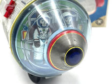 Load image into Gallery viewer, Close-up detail of the vintage battery-operated space capsule toy featuring a transparent dome and colorful interior.