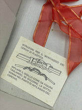 Load image into Gallery viewer, Ferrari Mazzini detail view of an angled red ribbon with printed tag.