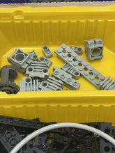 Carica l'immagine nel visualizzatore di Gallery, Close-up of gray LEGO parts in a storage bin, highlighting plastic pieces.