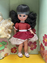 Load image into Gallery viewer, Front view of Migliorati Bambola Vania doll wearing a red dress and white shoes.