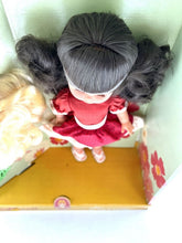 Load image into Gallery viewer, Top view of Migliorati Bambola Vania doll with pigtails in boxed display.