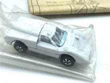 Load image into Gallery viewer, Detail showing red items in plastic wrap, including several strips.