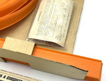 Load image into Gallery viewer, Detail close-up of an orange track piece alongside instruction paper.
