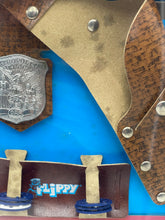 Load image into Gallery viewer, Close-up detail of the brown holster and silver badge with fasteners.