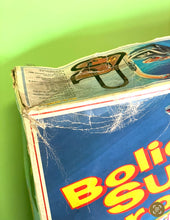 Load image into Gallery viewer, Detail close-up of the damaged corner of the Tyco box with colorful graphics.