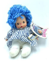 Carica l'immagine nel visualizzatore di Gallery, Front view of the Patapouf New Girl doll with blue curly hair and striped dress.
