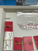 Load image into Gallery viewer, R.P. Il gioco delle relazioni pubbliche MERCATALI &amp; ASSOCIATI vintage detail of red boxes with rubber bands.
