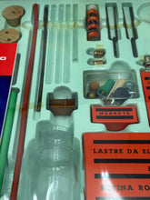 Load image into Gallery viewer, Close-up detail of the science kit components including various tools and instruction manual.
