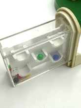 Load image into Gallery viewer, Detail close-up of a clear container with three compartments and colorful items inside
