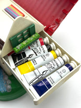 Load image into Gallery viewer, Close-up of organized paint tubes in yellow, blue, red, and white on a white background.
