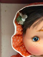 Load image into Gallery viewer, Detail close-up of the doll's face with flower accessory.
