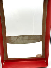 Load image into Gallery viewer, Front view of the red frame with transparent opening and label.
