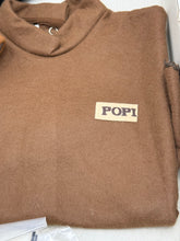 Load image into Gallery viewer, Detail view of brown sweatshirt featuring a logo patch and high collar.
