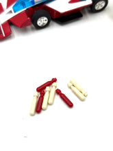 Load image into Gallery viewer, Detail view of small plastic pieces in various shapes and colors.
