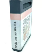 Load image into Gallery viewer, Side view of the Tintin on the Moon game cartridge displaying title text and spine design.
