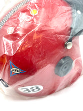 Load image into Gallery viewer, Detail close-up of a red helmet showing vent holes and plastic wrap.
