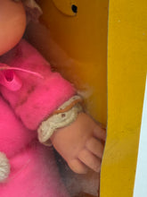 Load image into Gallery viewer, Close-up detail of the doll's gloved hand inside the packaging.
