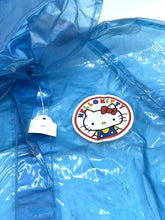 Carica l'immagine nel visualizzatore di Gallery, Close-up detail of the Hello Kitty patch on the blue raincoat.

