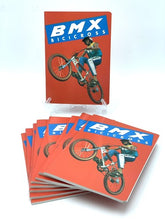 Carica l'immagine nel visualizzatore di Gallery, Vintage BMX notebook in a lifestyle setting with stacked books and an illustrated cover.
