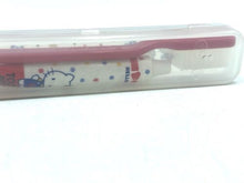 Carica l'immagine nel visualizzatore di Gallery, Hello Kitty toothbrush set close-up detail of the pencil case's colorful accents.
