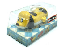 Load image into Gallery viewer, Side view of the yellow Bandai Wind-up Swimming and Walking Dog in transparent packaging.
