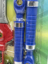 Load image into Gallery viewer, Close-up detail of blue toy weapons with circular ends and striped designs.
