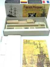 Load image into Gallery viewer, Mamoli Captain Morgan model kit contents close-up with wooden ship model and instruction manual.
