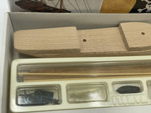 Load image into Gallery viewer, Detail shot of various wooden model parts in a plastic container.

