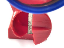 Load image into Gallery viewer, Detail close-up of a red plastic object with curved design and interior compartment.
